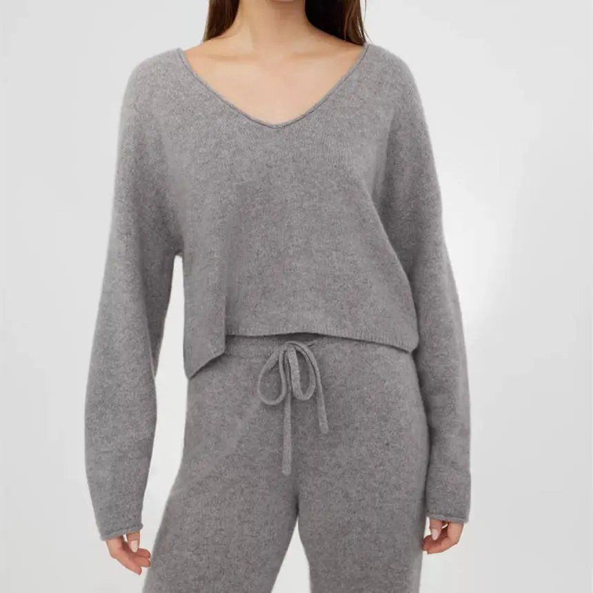 Model wearing a gray V-neck sweater with dropped shoulders.
