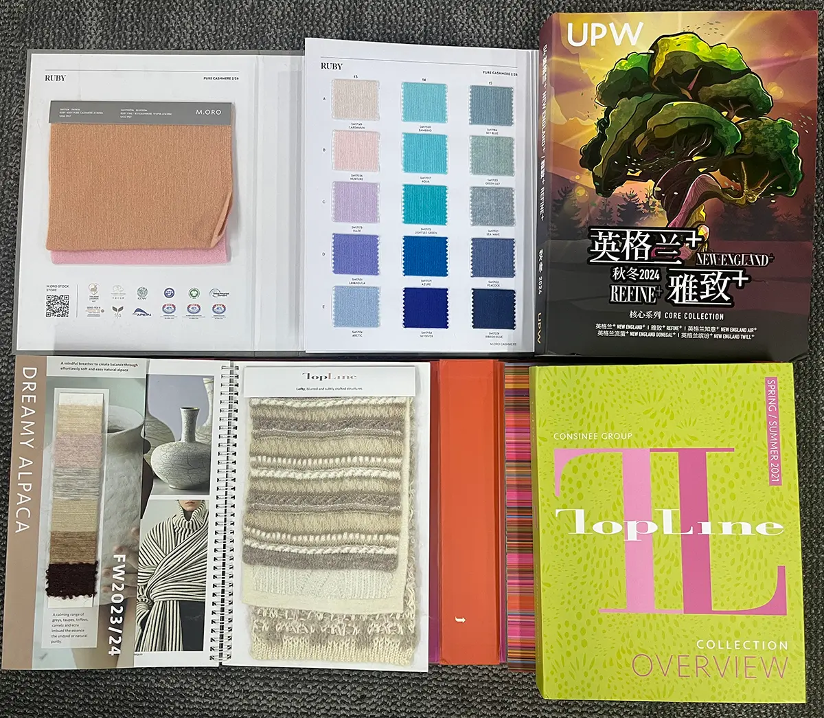 Yarn supplier sample books with knitted swatches, color cards, and UPW, M.ORO, and Consinee Topline covers.