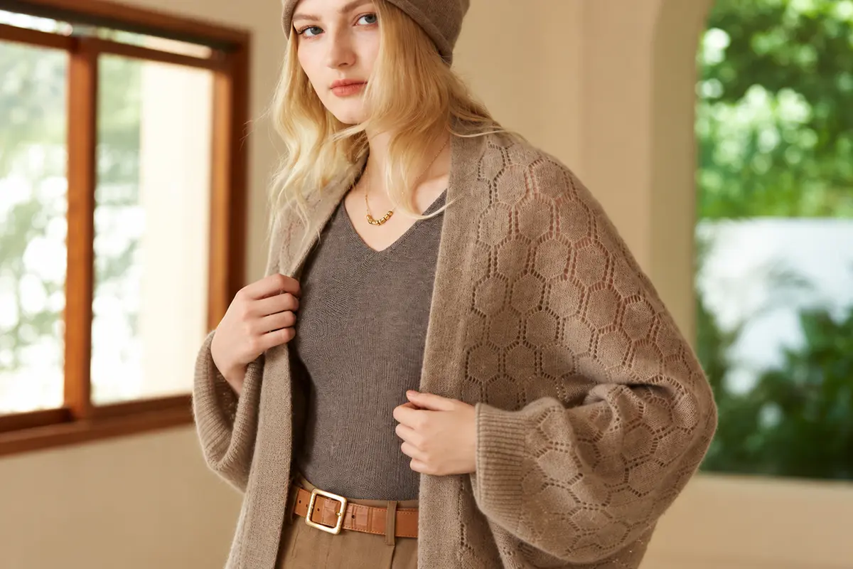 Woman wearing a taupe knit cardigan over a matching V-neck top.